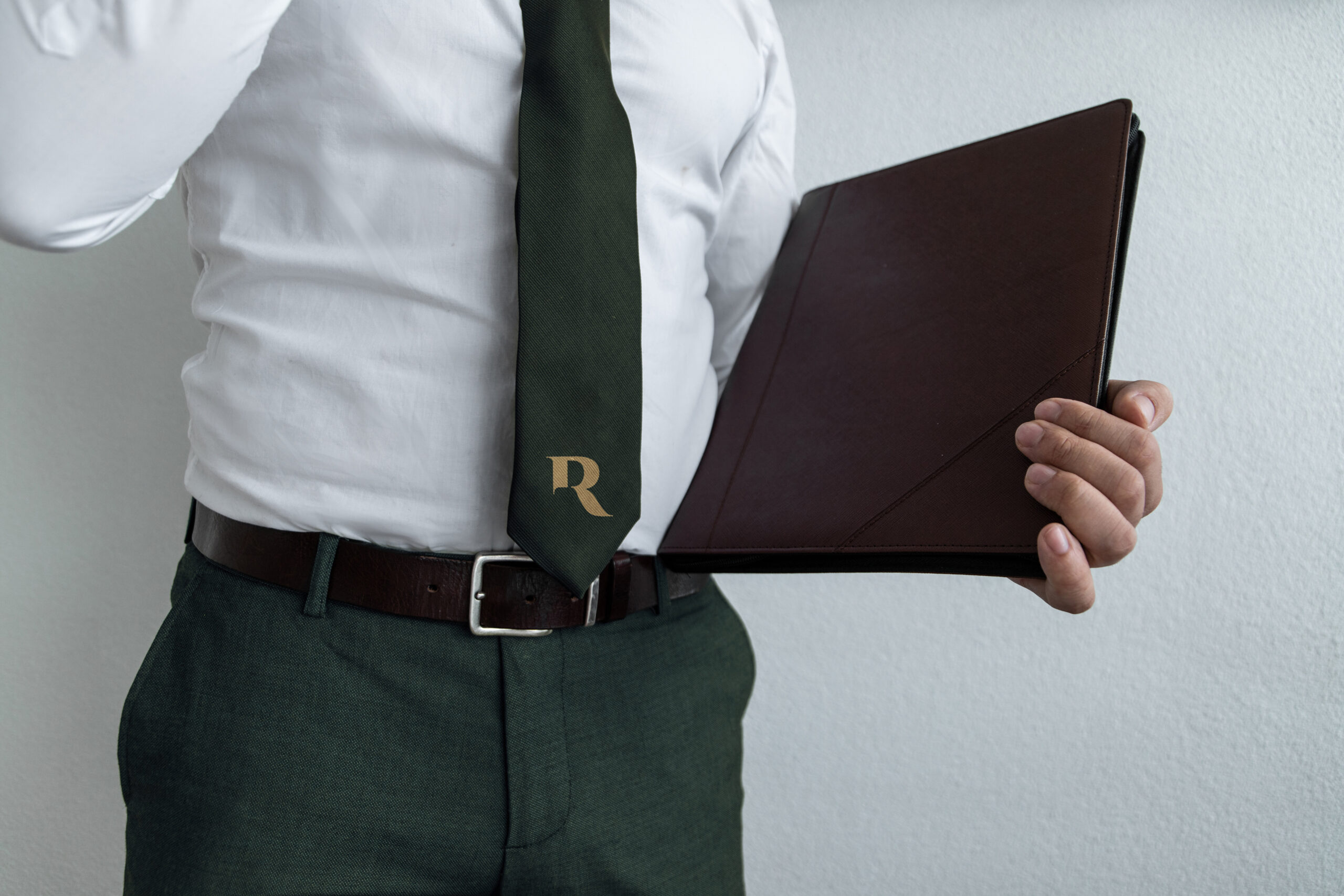 Jurist van Representum met leren portfolio en de groene das met het gouden R-logo.